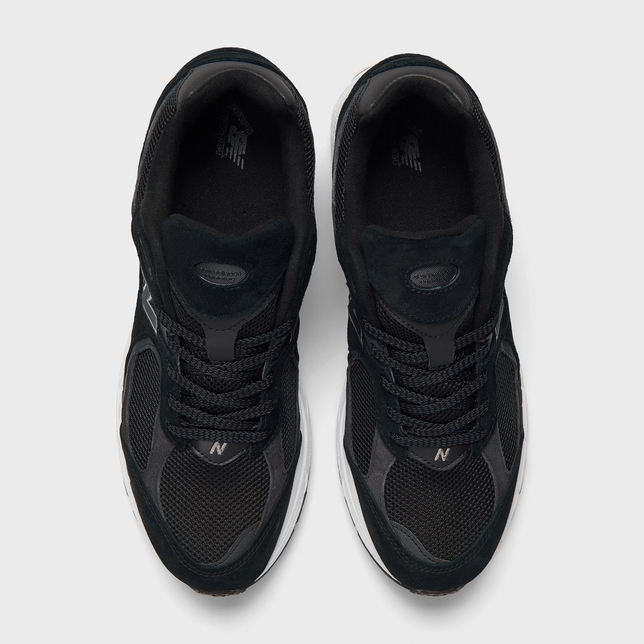 New Balance M2002RBK Black / Phantom running in a swamp area shoes